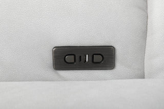 Close-up of a metallic control panel on a gray fabric sofa