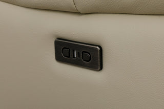 Close-up of a beige leather surface with a metallic control panel.