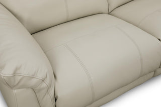 Close-up of a beige leather sofa with visible stitching