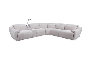 A light beige upholstered sectional recliner sofa with a curved, U-shaped design and a small black floor lamp placed beside it, shown on a plain white background.