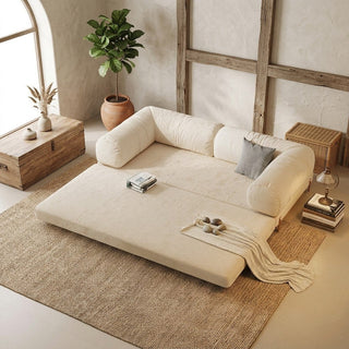 Beige designer sofa bed in a room with wooden furniture and plants
