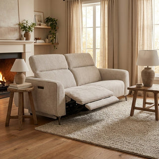 Beige recliner sofa in a cozy living room with wooden tables, lamps, and plants.
