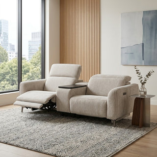 Beige recliner sofa in a modern living room with large windows and a painting on the wall.