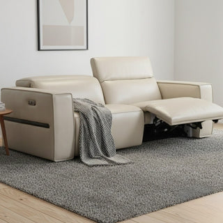 Beige recliner sofa with a blanket on a gray rug in a living room setting.