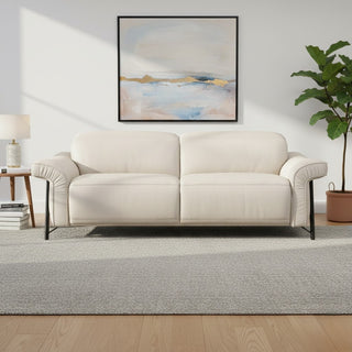 Beige sofa in a living room with a abstract painting on the wall and a plant.