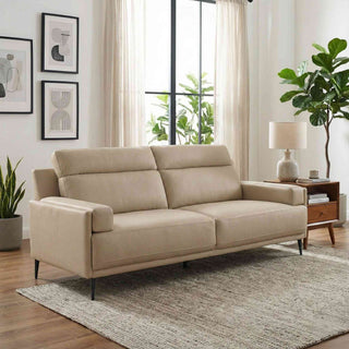 Beige sofa in a living room with plants and a window