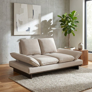 Beige sofa in a modern living room with abstract art and a plant.