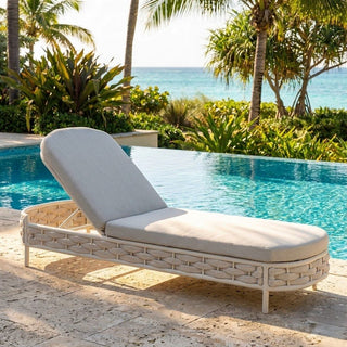 Beige wicker lounge chair with gray cushion by a pool with palm trees and ocean view