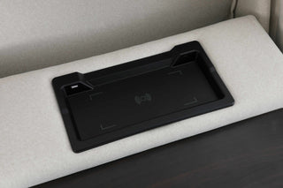 Black tray on a gray couch with a wireless charger inside