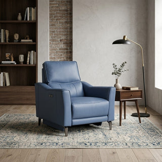 Blue armchair in a living room setting with a bookshelf and lamp.