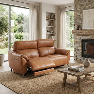 Brown leather recliner sofa in a living room with a fireplace and large windows.