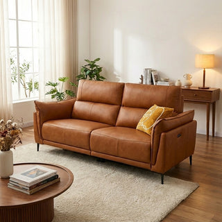 Brown leather sofa in a living room with a coffee table and decorative items.
