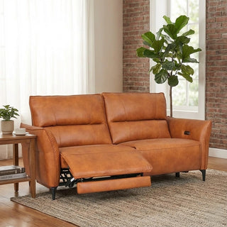Brown leather sofa in a living room with a plant and side table.