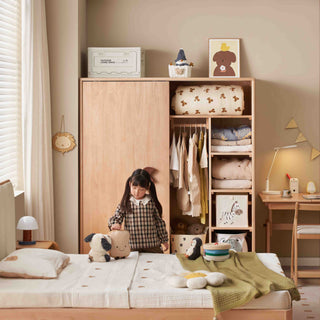 Child playing in a bedroom with wooden wardrobe and bed