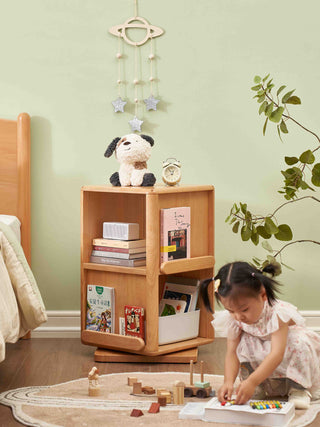 Child playing near a wooden bookshelf in a room with a green wall and plant.