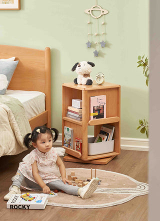 Child playing on the floor next to a wooden bookshelf in a room with a bed and toys.