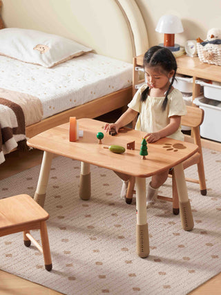 Child playing with toys on a wooden table in a bedroom