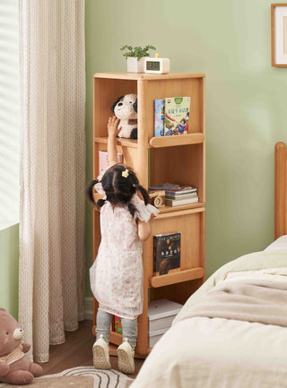 Child reaching up to a Montessori Rotating Bookshelf in a room with green walls and a bed.
