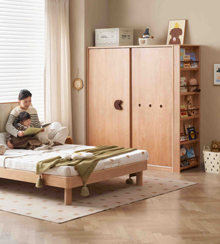 Children's bedroom with wooden bed, wardrobe, and bookshelf.