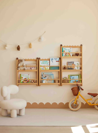 Children's room with wooden bookshelf, white chair, and yellow balance bike against a light wall.