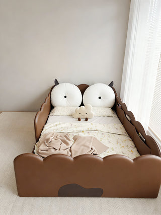 Children's bed with animal design in a room with a window.