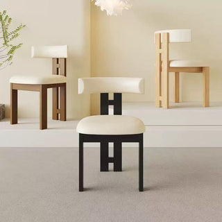 Dining chairs with white cushions in a minimalistic room.