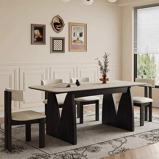 Dining room with a modern table and chairs, decorated with wall art and a plant.