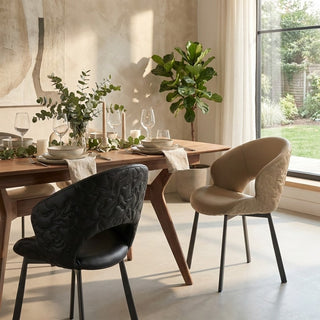 Dining room with a wooden table and modern chairs, including a black chair and beige chairs.