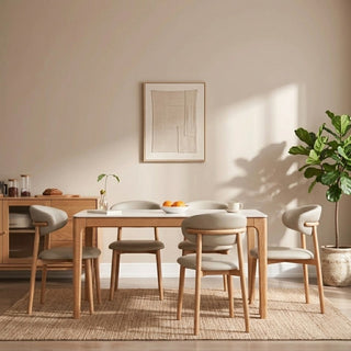 Dining room with sintered stone dining table with wooden leg and chairs, plant, and framed artwork on the wall.