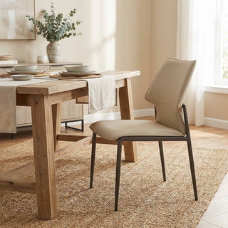 Dining room with wooden table and beige chair on a textured rug