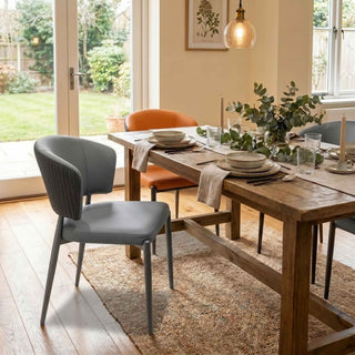 Dining room with wooden table and chairs, including a gray chair and an orange chair.