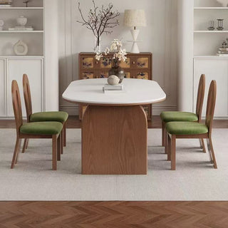 Dining room with wooden table and chairs, white walls, and decorative elements.