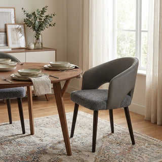 Dining room with wooden table and gray chairs near a window.