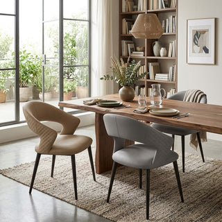 Dining room with wooden table and modern chairs near a large window with plants outside.
