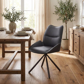 Dining room with wooden table, dark grey chair, and potted plants.