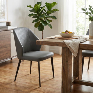 Dining room with wooden table, gray chair, and potted plant.