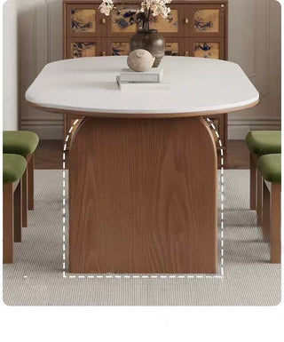 Dining table with marble top and wooden base in a room setting