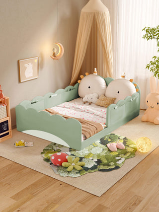 Children's room with a green bed, decorative pillows, and a rug with cartoon characters.