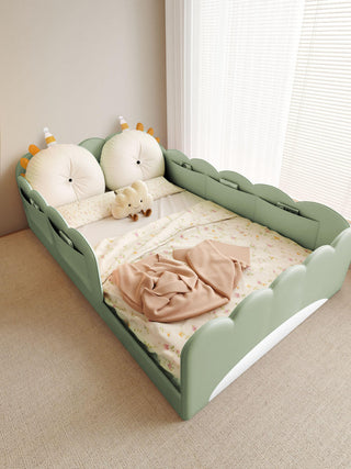 Children's bed with green frame and white mattress, featuring a teddy bear and pink blanket.