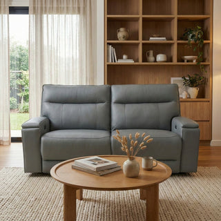 Gray sofa in a living room with a wooden coffee table and bookshelf.