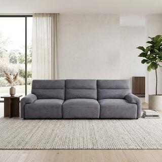 Grey 4 seater slider sofa in a modern living room with a plant and window in the background.