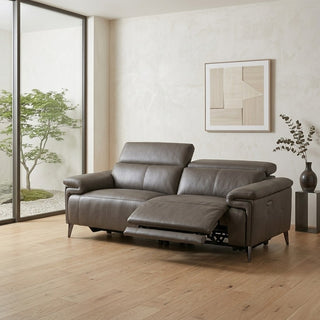 Grey leather recliner sofa in a modern living room with large windows and abstract art on the wall.