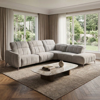 Grey sectional sofa in a living room with large windows and a wooden coffee table.
