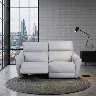 Grey sofa in a modern living room with large windows and a cityscape view.
