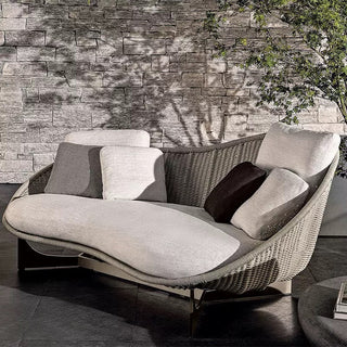 Modern outdoor sofa with cushions against a stone wall