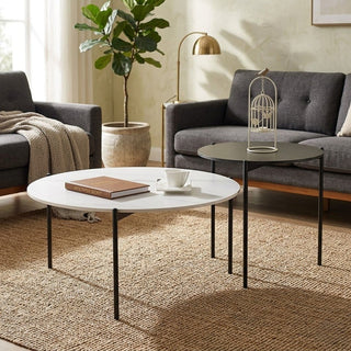 Living room with circle coffee table, gray sofa, and decorative elements.