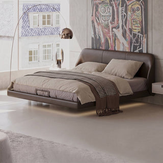 Modern bedroom with a brown leather bed and abstract art on the wall.