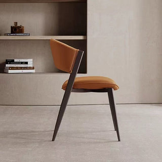 Modern dining chair with brown cushioned seat and backrest in a minimalistic room.