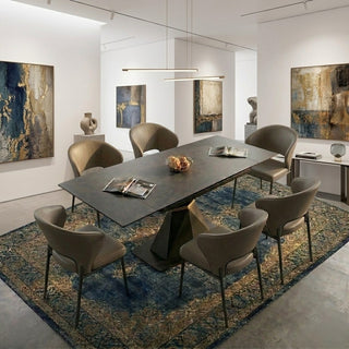 Modern dining room with a long dark grey extendable table and six chairs, featuring abstract art on the walls.
