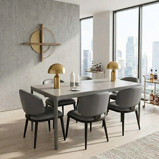 Modern dining room with a long sintered stone table and chairs, gold lamps, and cityscape view.